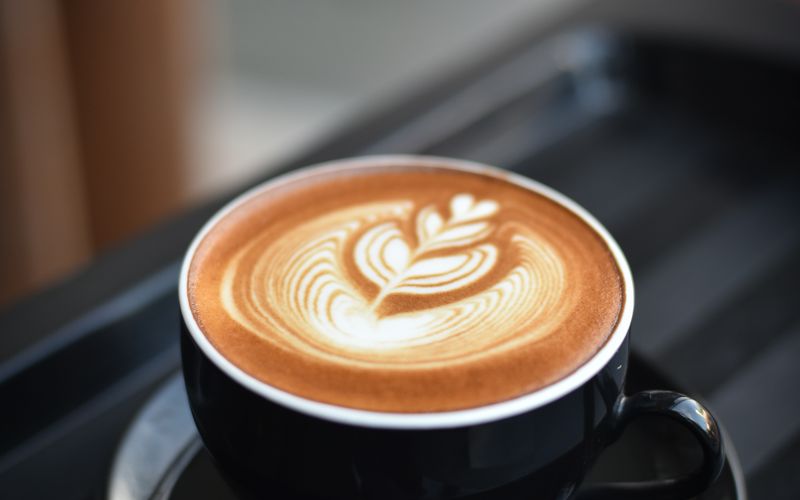 Cafecito con arte en taza negra